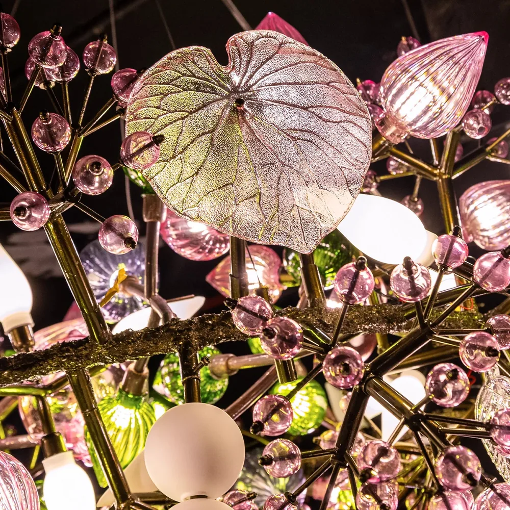 Close-up of the Pandora Chandelier showing translucent glass leaves, pink ribbed glass fruits and opal white globes on brass stems